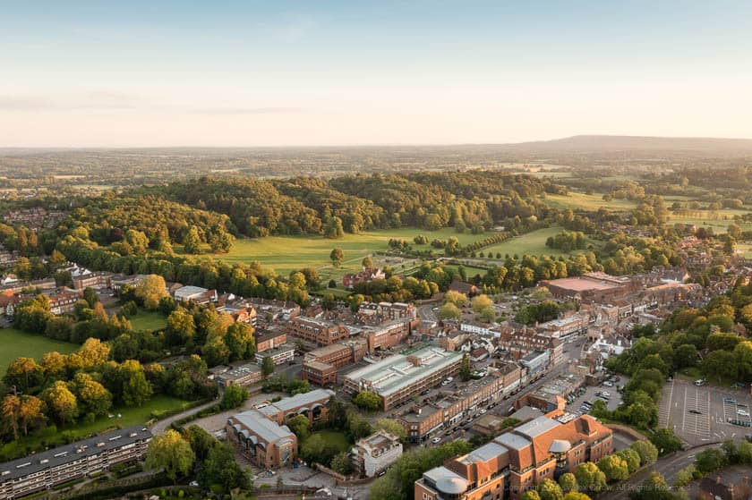 Drone view of Reigate Town Centre and Priory Park during sunset.